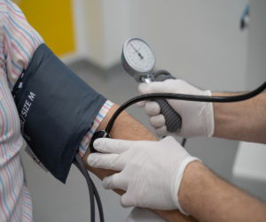 Zu sehen ist ein Männerarm, an dem der Blutdruck gemessen wird.
